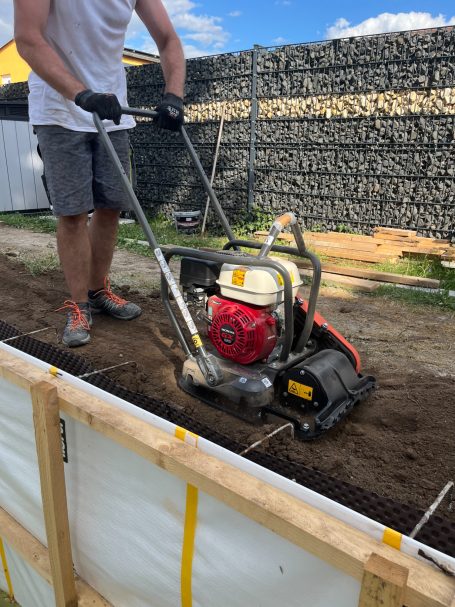 Mann bedient Husqvarna LFV 80 Rüttelplatte und verdichtet den Boden. LCW Maschinenverleih in Teutschenthal. Hochwertige Baumaschinen mieten!